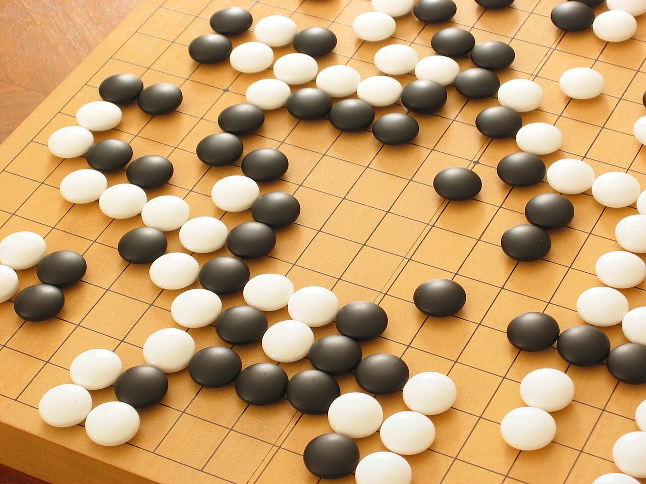 돌이 여러 개 놓인 채 대국이 진행 중인 바둑판