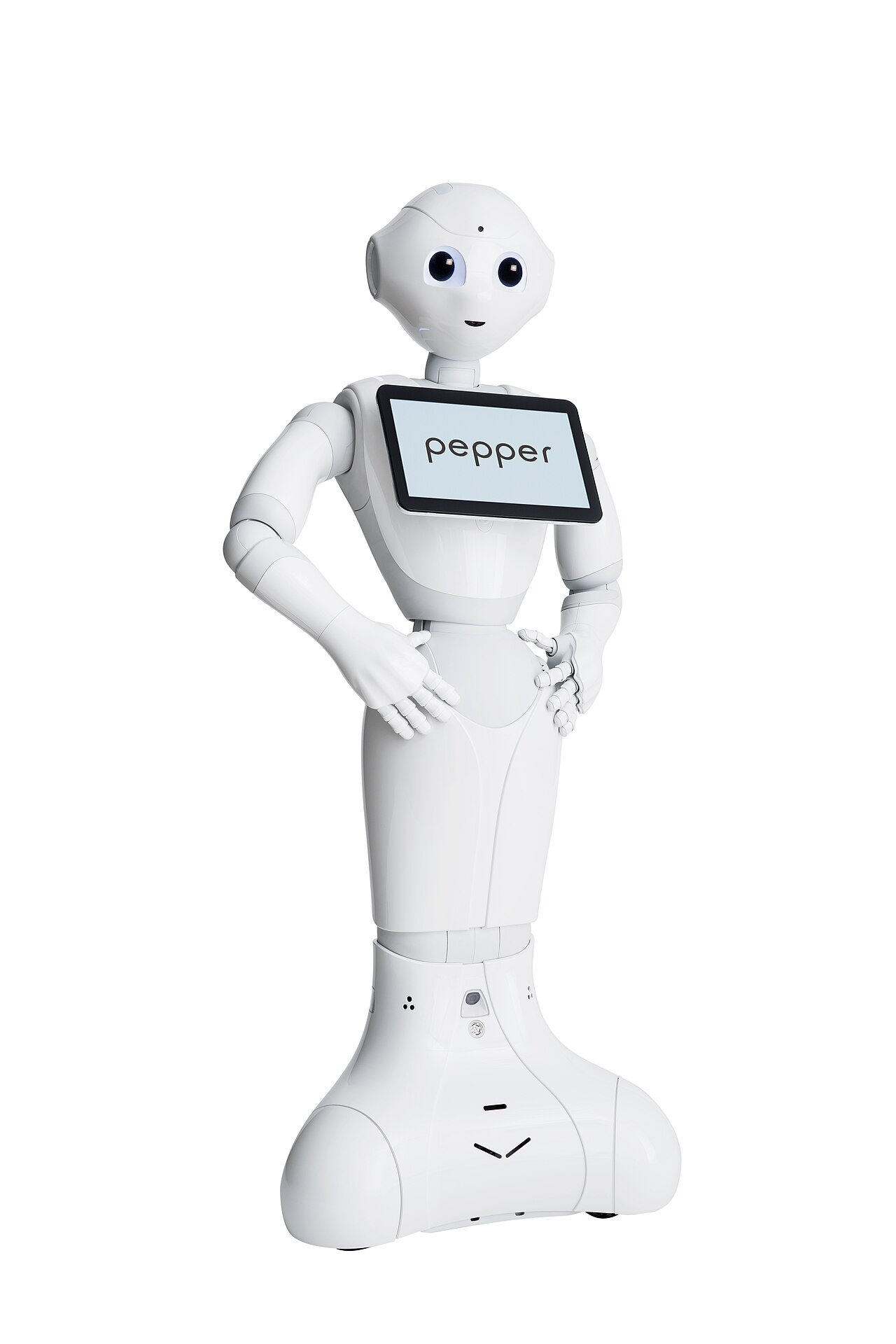 흰 배경 앞에 선 흰색 소셜 로봇 페퍼. 큰 검은 눈과 작게 웃는 입, 가슴의 화면에 pepper라는 글자가 떠 있고 두 손을 허리에 얹고 있다